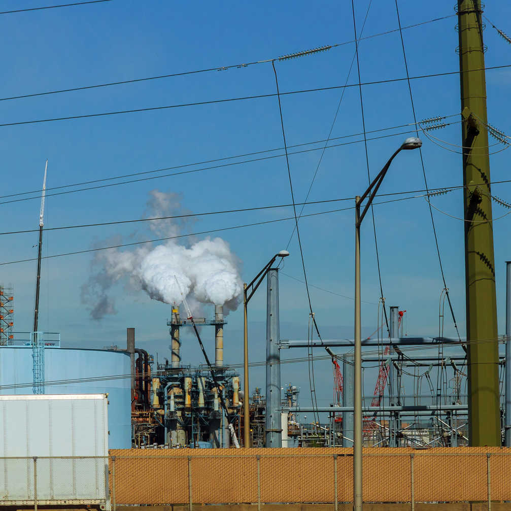 Engineers Standing On Surrounded By Pipelines