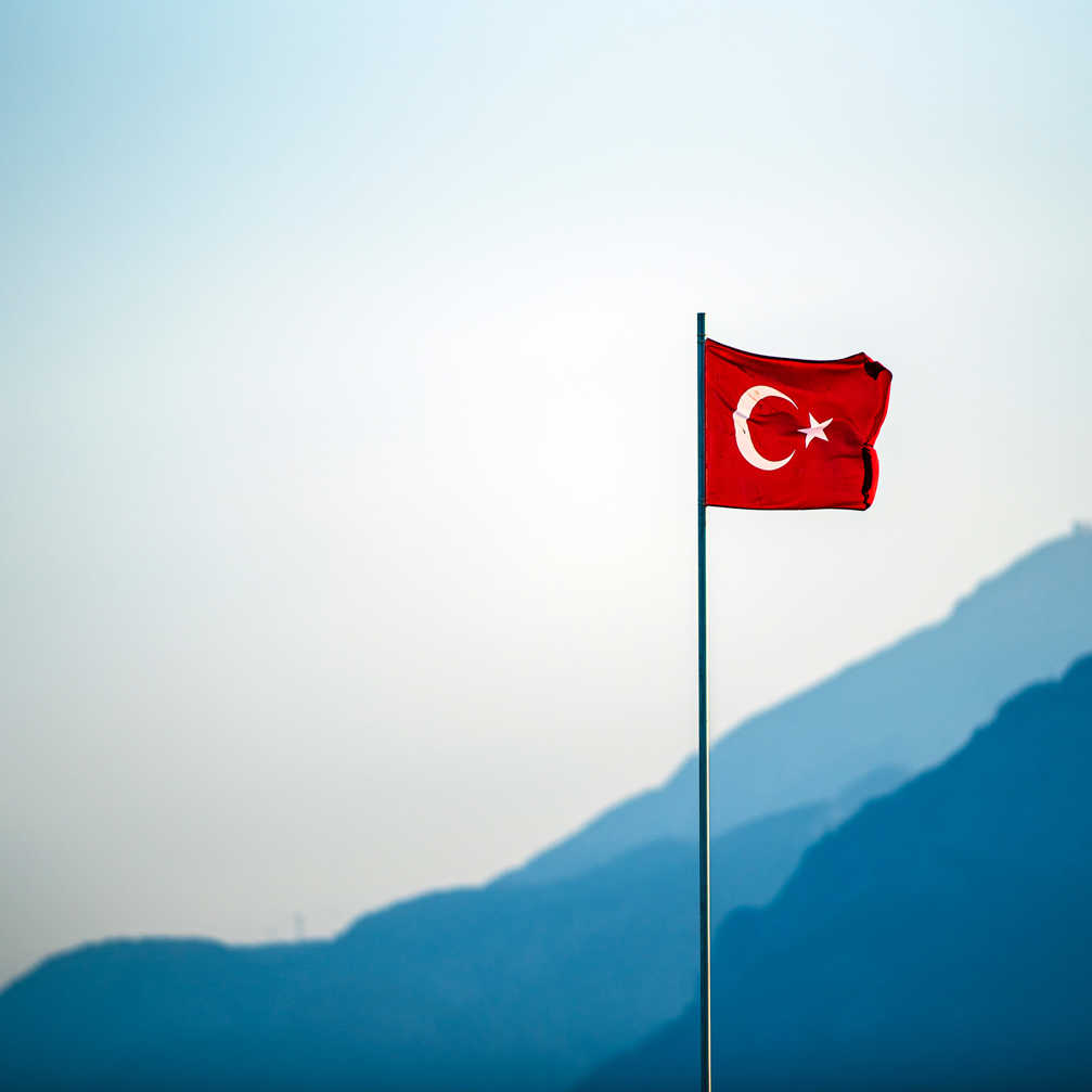 Turkish Flag Waving On The Wind With Mountains