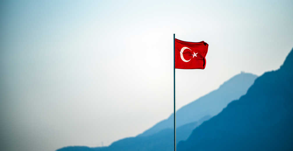 Turkish Flag Waving On The Wind With Mountains